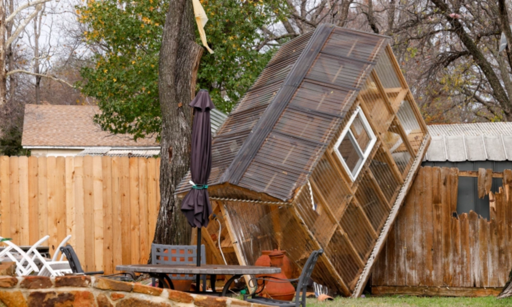 Un invernadero sobre una cerca en el patio trasero de la casa de Randy Popiel después de un posible tornado en Grapevine, Texas, el martes 13 de diciembre de 2022. (Elías Valverde II/The Dallas Morning News vía AP)