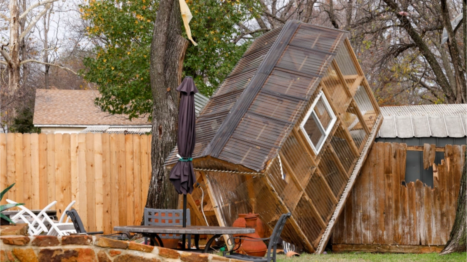 Un invernadero sobre una cerca en el patio trasero de la casa de Randy Popiel después de un posible tornado en Grapevine, Texas, el martes 13 de diciembre de 2022. (Elías Valverde II/The Dallas Morning News vía AP)