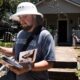 El cartero Rhett Hanes usa un gorro para protegerse de los ataques de halcones mientras entrega el correo en Milan Place y Kenwood Ave. en Travis Heights, el 12 de julio de 2023, en Austin. El Servicio Postal de Estados Unidos ha suspendido la entrega de correo en el área por los repetidos ataques de dichas aves en lo que va del mes.(Kara Hawley)