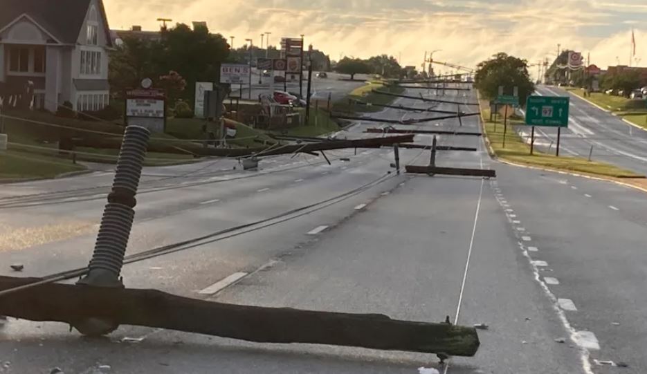 Los postes de electricidad caídos yacen a lo largo de la Ruta 140 en Westminster, Maryland, el lunes 7 de agosto de 2023. (Baltimore Sun Staff/The Baltimore Sun vía AP)