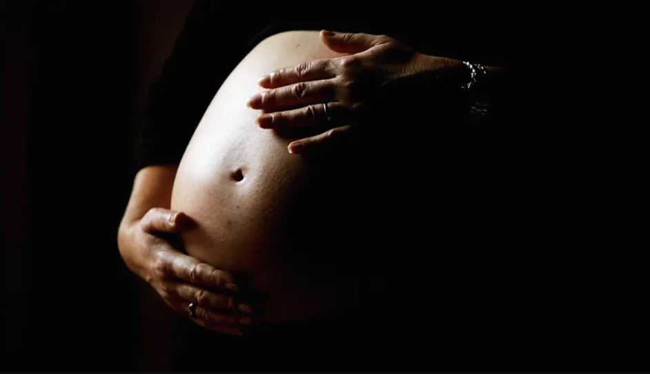 Una mujer embarazada no identificada se sostiene el estómago. (Foto de Ian Waldie/Getty Images)