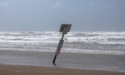 Un cartel inclinado por el viento huracanado en la paya Surfside Beach, de Texas (REUTERS/Adrees Latif)