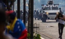 Manifestantes corren durante enfrentamientos entre opositores y miembros de la Guardia Nacional Bolivariana (GNB), por los resultados de las elecciones presidenciales de julio en Caracas. | Fuente: AFP