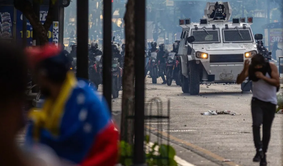 Manifestantes corren durante enfrentamientos entre opositores y miembros de la Guardia Nacional Bolivariana (GNB), por los resultados de las elecciones presidenciales de julio en Caracas. | Fuente: AFP