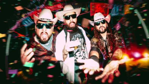 Three men in cowboy hats and sunglasses pose toward the camera while confetti falls around them at a lively party?performance vibe.
