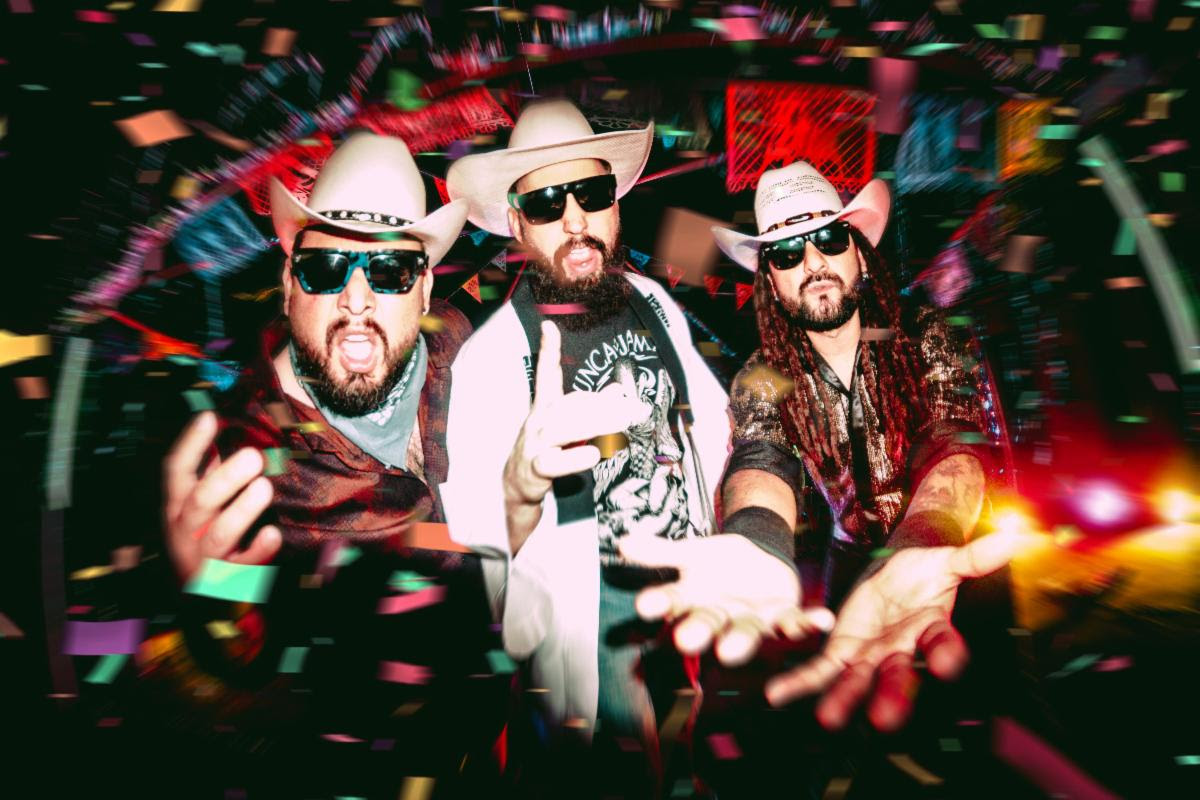 Three men in cowboy hats and sunglasses pose toward the camera while confetti falls around them at a lively party?performance vibe.