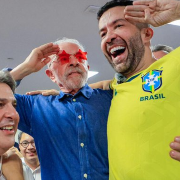 Group of men celebrating together; one wears a Brazil yellow jersey, others smile and pose for a selfie.