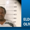 Mugshot of Eldrick Oliver standing before a height chart, with a blue banner showing his name on the right.