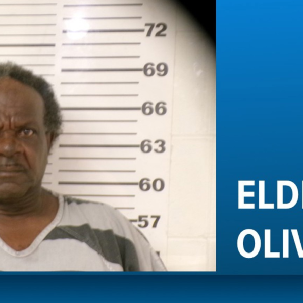 Mugshot of Eldrick Oliver standing before a height chart, with a blue banner showing his name on the right.