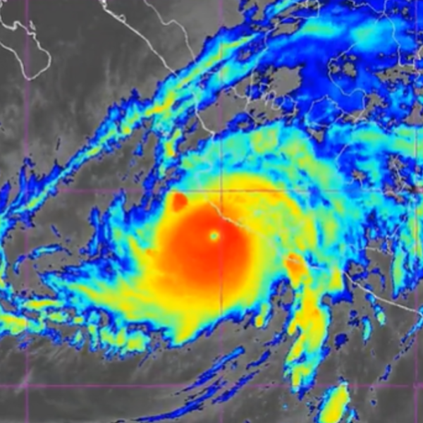 Tropical cyclone with a distinct eye, bright red center and surrounding yellow and blue rain bands on a satellite radar map.