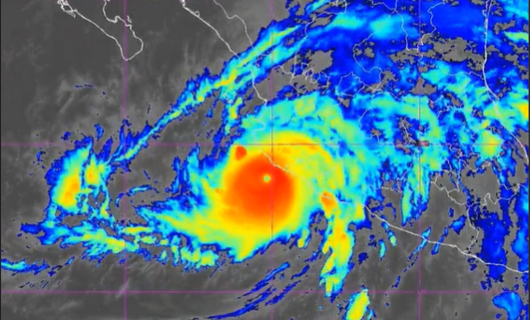 Tropical cyclone with a distinct eye, bright red center and surrounding yellow and blue rain bands on a satellite radar map.