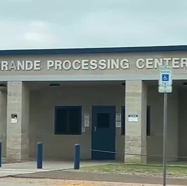 Front view of a building labeled Rio Grande Processing Center with blue doors and columns.