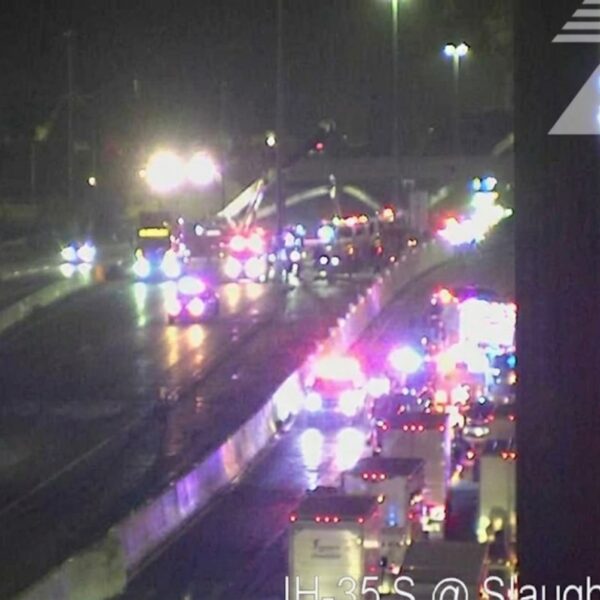 Nighttime highway incident with numerous emergency vehicles and flashing red/blue lights on IH-35 South near Slaughter Creek (TxDOT watermark).
